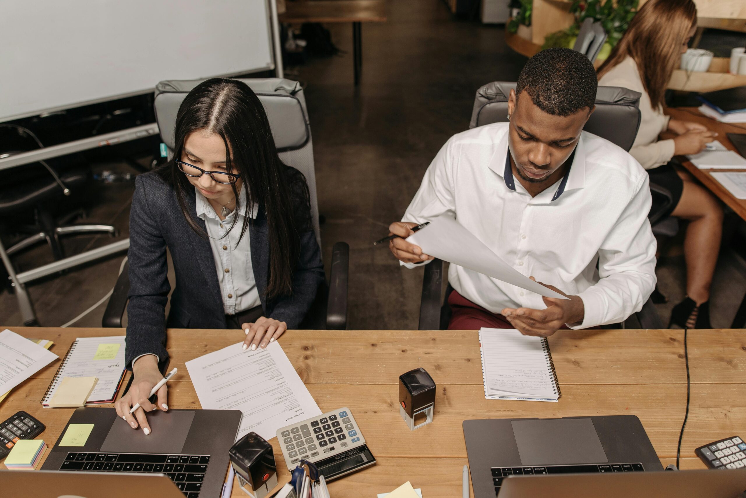 Multiracial office team working on financial documents, highlighting teamwork and productivity.